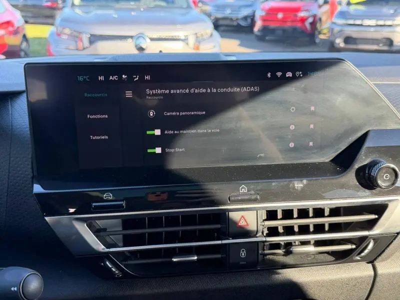 Écran tactile du système d’aide à la conduite dans le tableau de bord d’une Citroën C4 2024 gris acier, vue intérieure frontale.