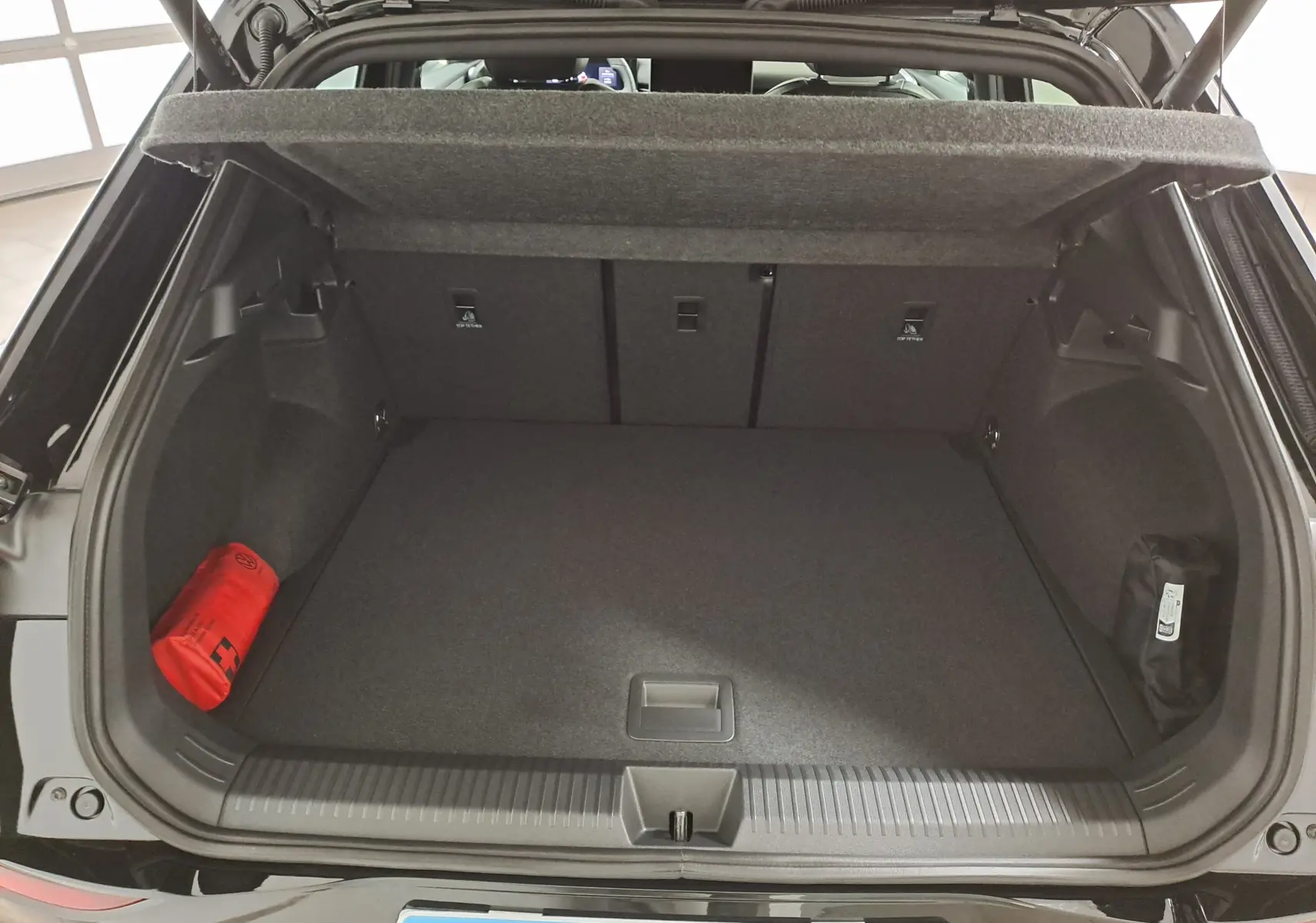 Coffre ouvert du Volkswagen T-Roc noir ébène 2026, vue arrière montrant un espace de rangement propre et organisé.