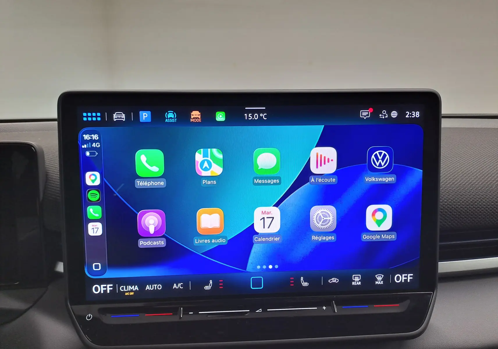 Écran tactile central du Volkswagen T-Roc 2026 affichant l'interface Apple CarPlay avec icônes colorées sur fond bleu.