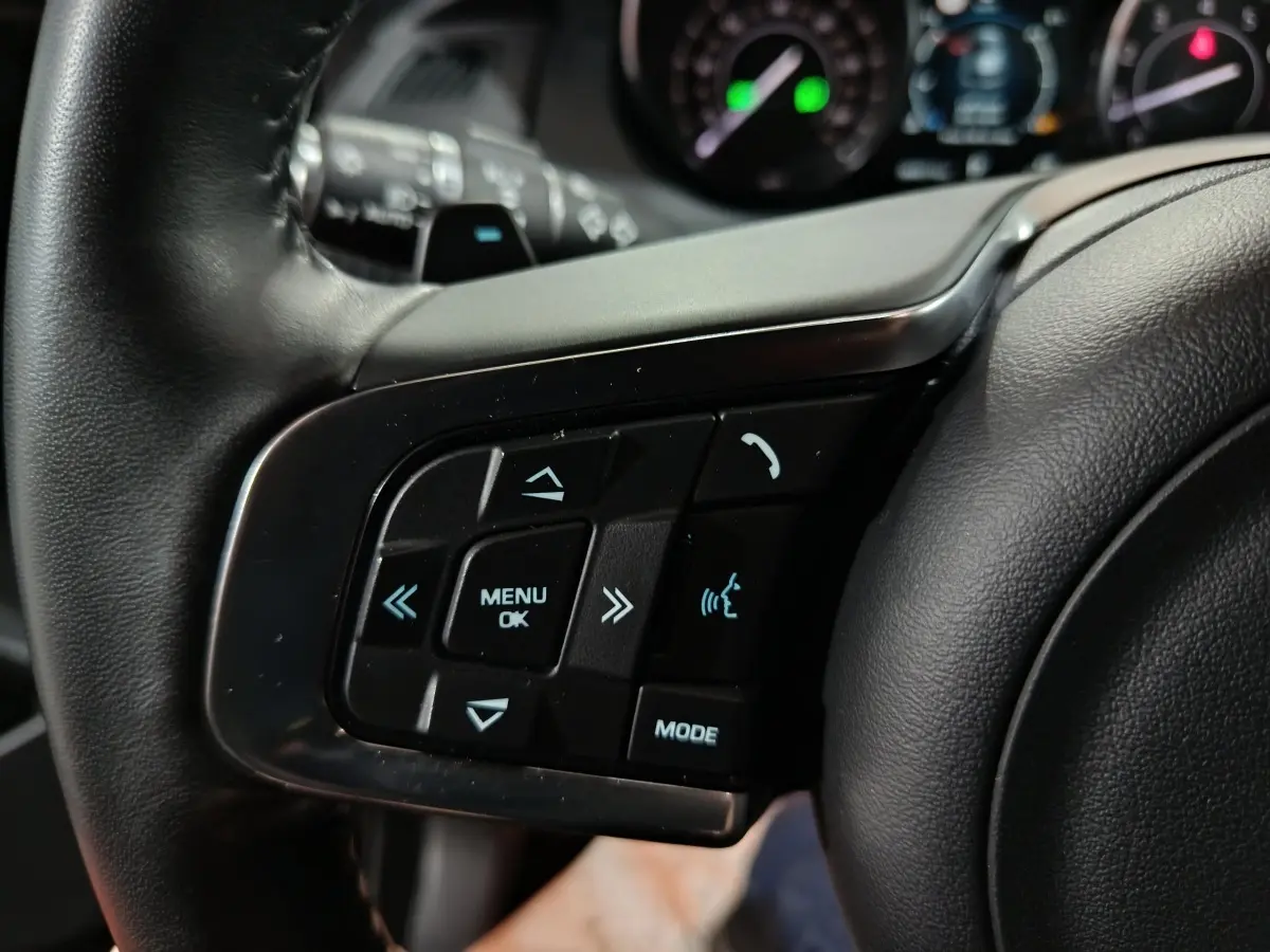 Gros plan sur les commandes multifonctions en cuir du volant gauche du Jaguar E-PACE noir, version 2019.