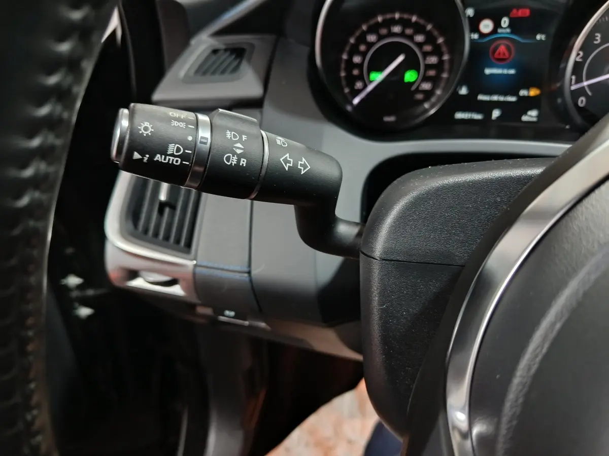 Gros plan sur la commande des phares et clignotants à gauche du volant cuir noir du Jaguar E-PACE P200 2019.