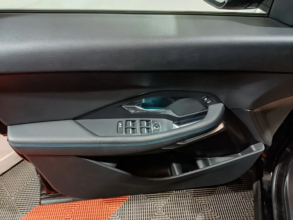 Vue rapprochée de la porte avant gauche noire du Jaguar E-PACE 2019, avec commandes électriques et finition cuir.