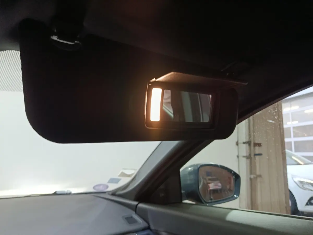 Détail intérieur du pare-soleil côté conducteur avec miroir éclairé sur Jaguar E-PACE noir, vue côté gauche.