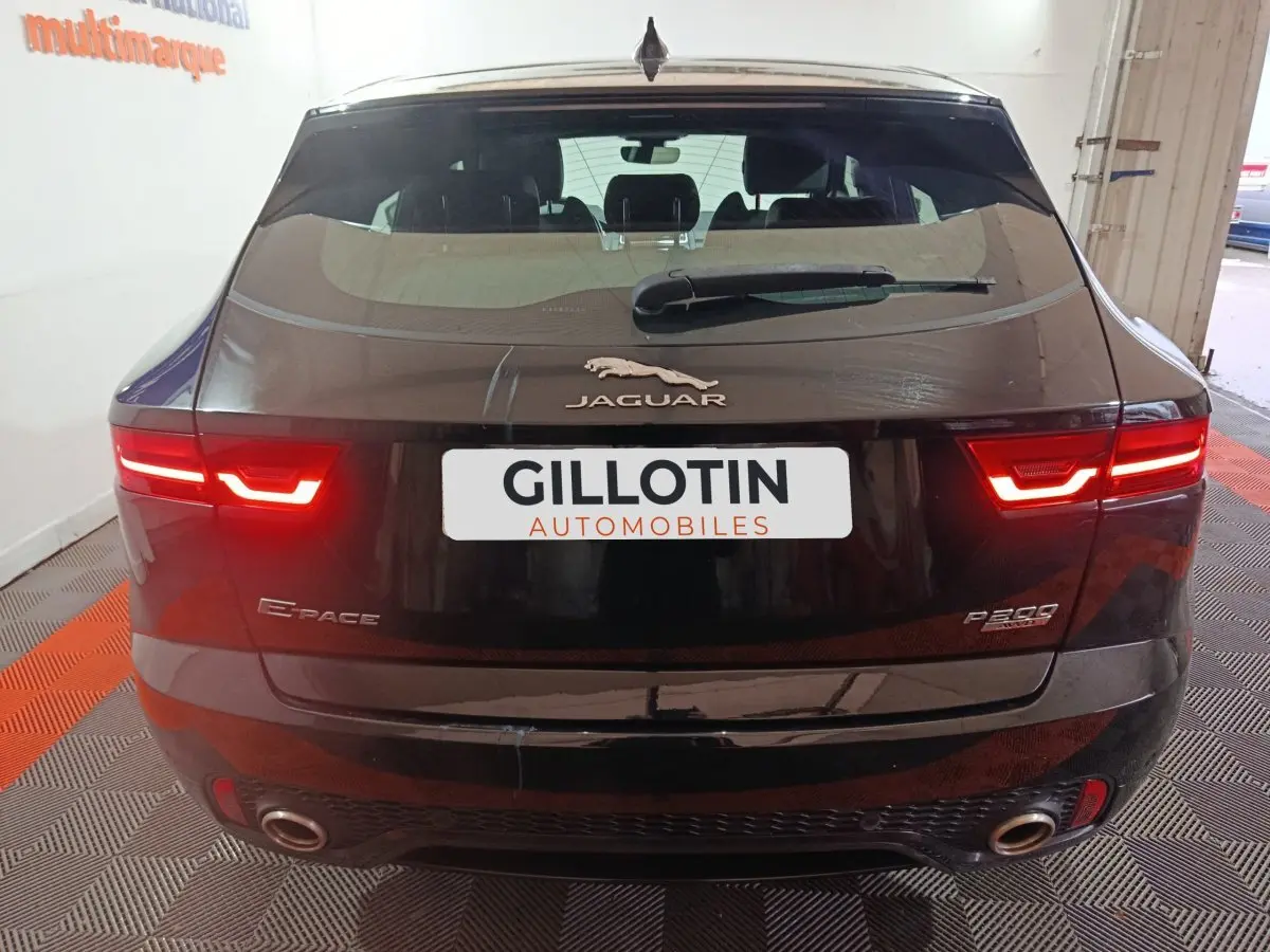 Vue arrière d'un Jaguar E-PACE noir 2019 avec feux LED allumés et double sortie d'échappement visible.