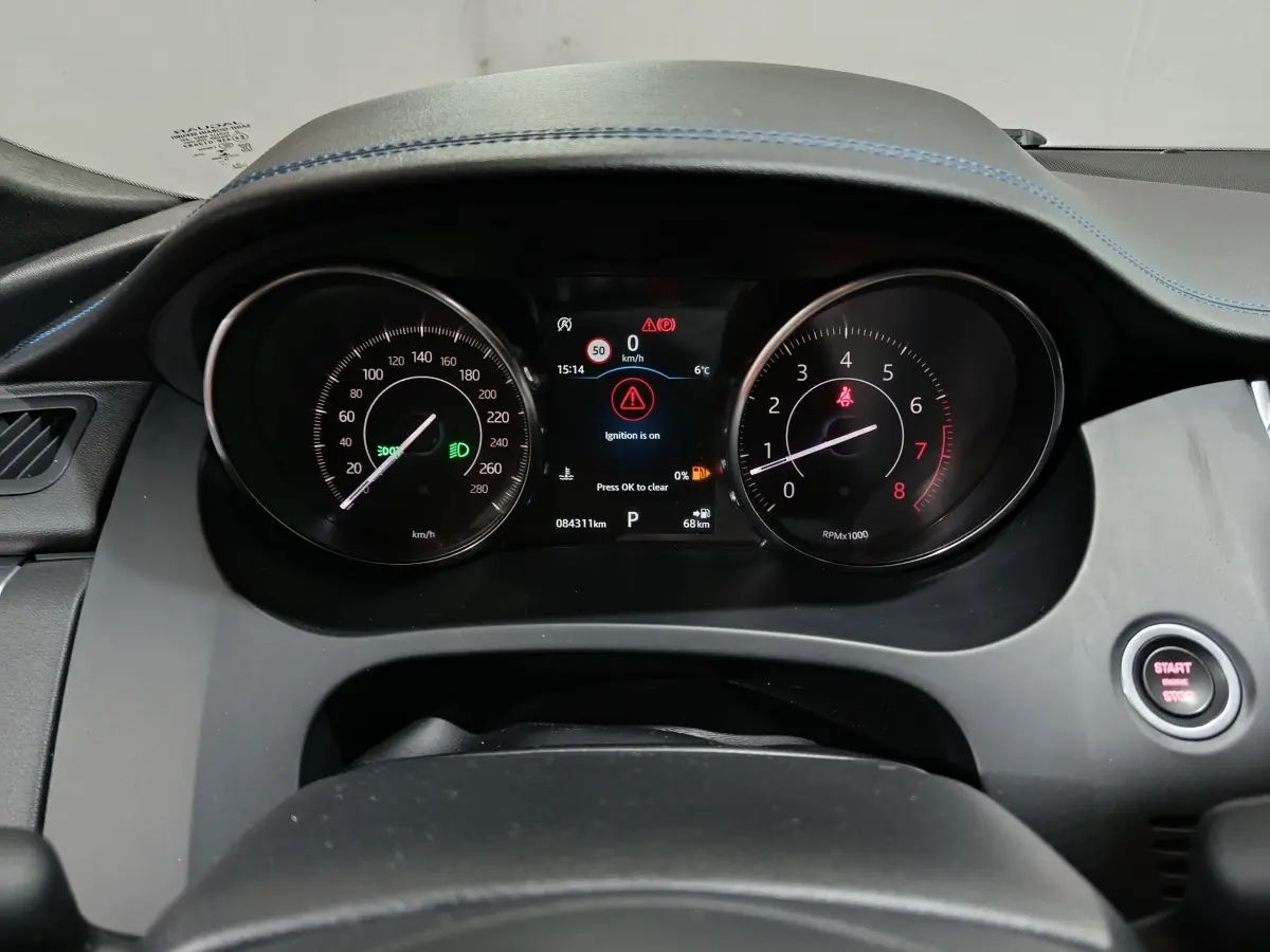 Vue rapprochée du tableau de bord noir du Jaguar E-PACE 2019 avec compteurs analogiques et écran digital central allumé.