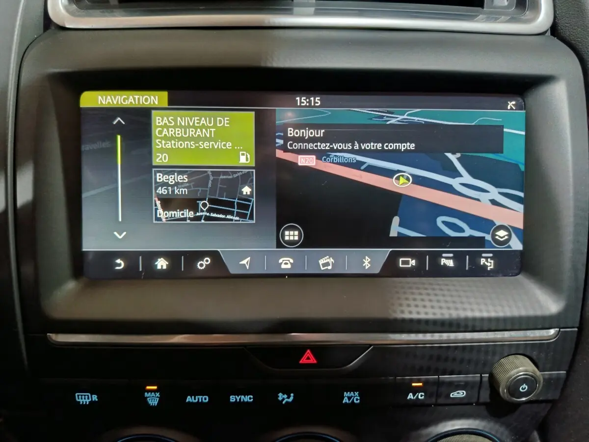 Vue rapprochée de l'écran tactile de navigation du tableau de bord d'une Jaguar E-PACE noire, affichant une carte et alertes.