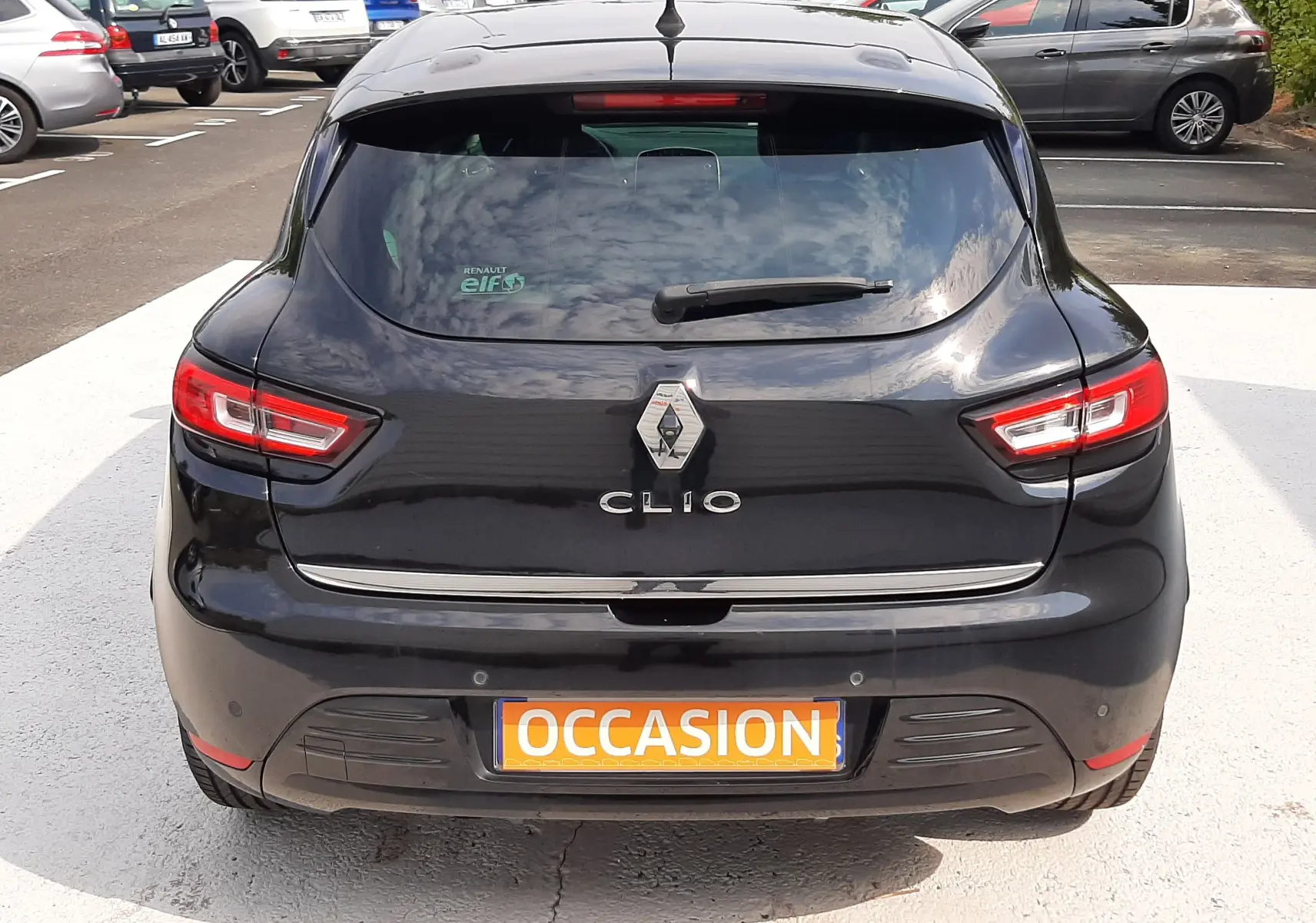 Vue arrière d'une Renault Clio IV noire 2018 avec feux LED et plaque d'occasion visible en parking extérieur.