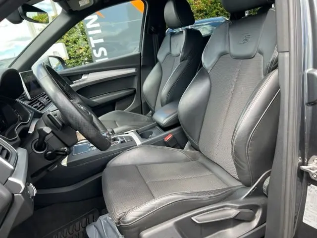 Intérieur de l'Audi Q5 2018 S Line, vue côté conducteur, sièges en cuir noir avec logo S embossé sur les appuie-têtes.
