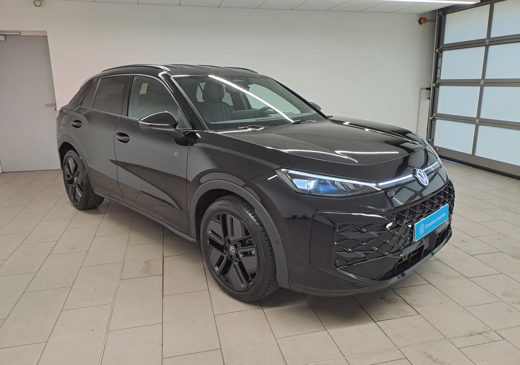 Volkswagen T-Roc 2026 noir ébène en 3/4 avant droit, avec jantes noires 19 pouces et phares matrix LED allumés.