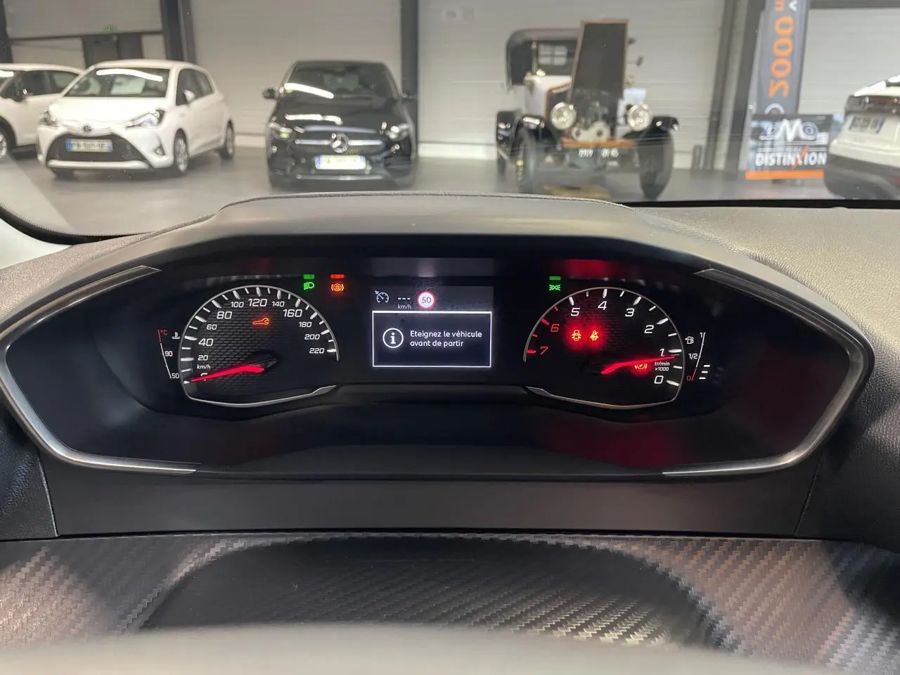 Vue rapprochée du combiné d'instruments Peugeot 208 2024 avec affichage numérique et compte-tours rouge.