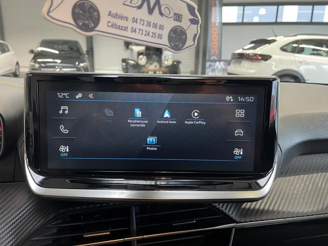 Écran tactile central du tableau de bord de la Peugeot 208 gris clair, avec interface multimédia affichée.