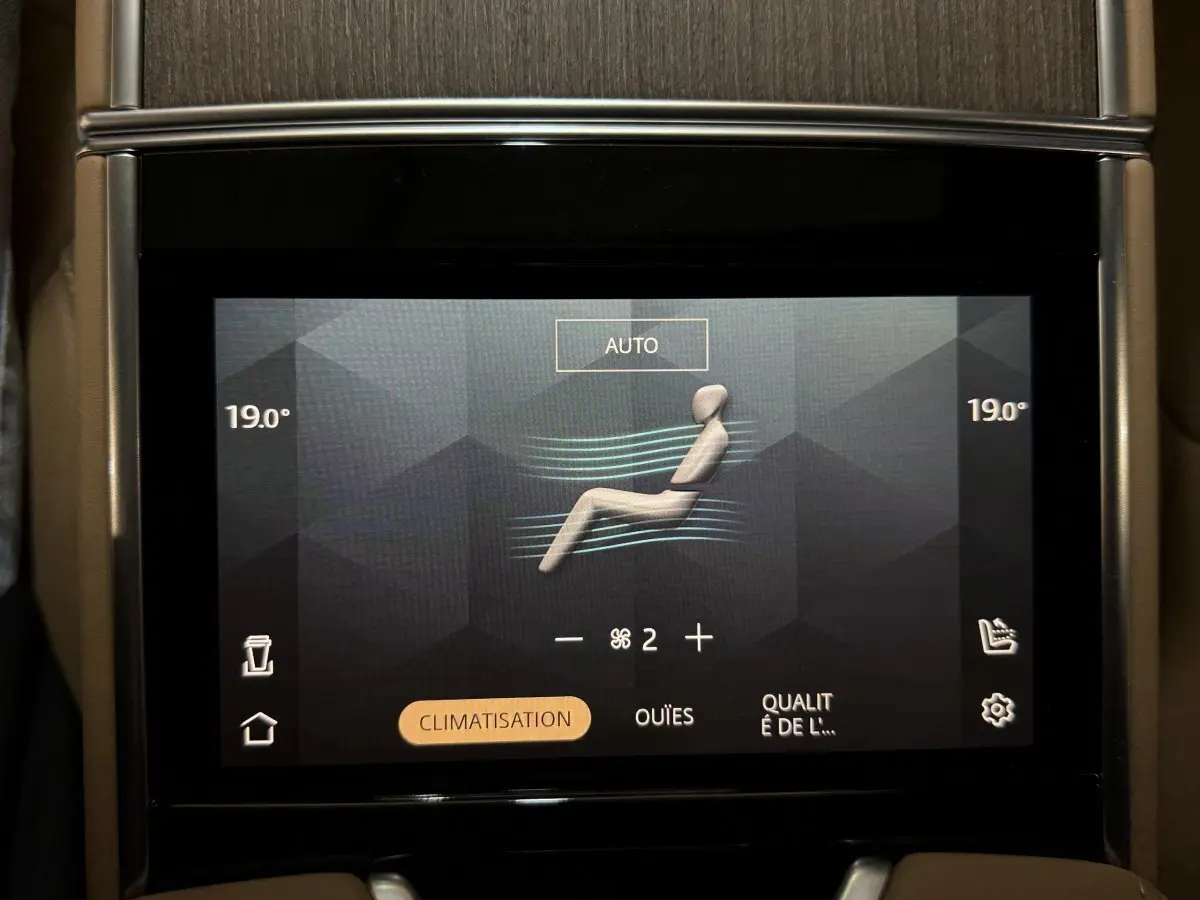 Écran tactile central affichant la climatisation à 19°C dans un Range Rover PHEV noir, vue intérieure rapprochée.