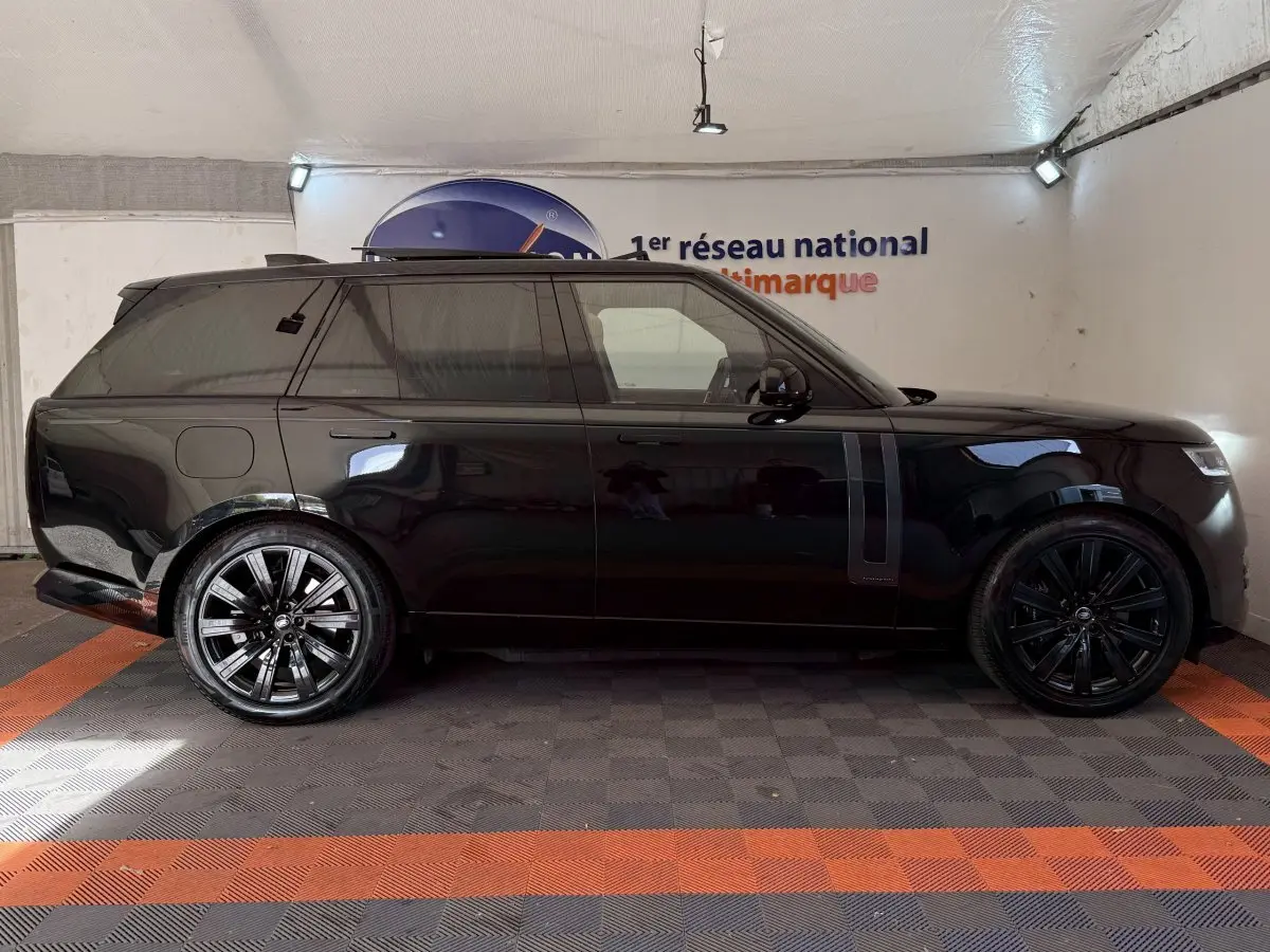 Vue de profil côté gauche d'un Range Rover PHEV P550e Autobiography noir brillant avec jantes noires en intérieur.