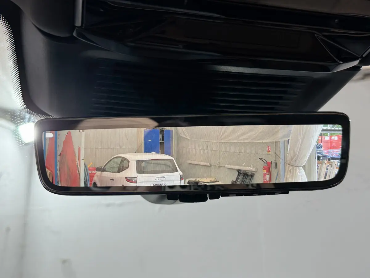 Vue arrière dans le rétroviseur intérieur montrant un Range Rover noir en stationnement intérieur.