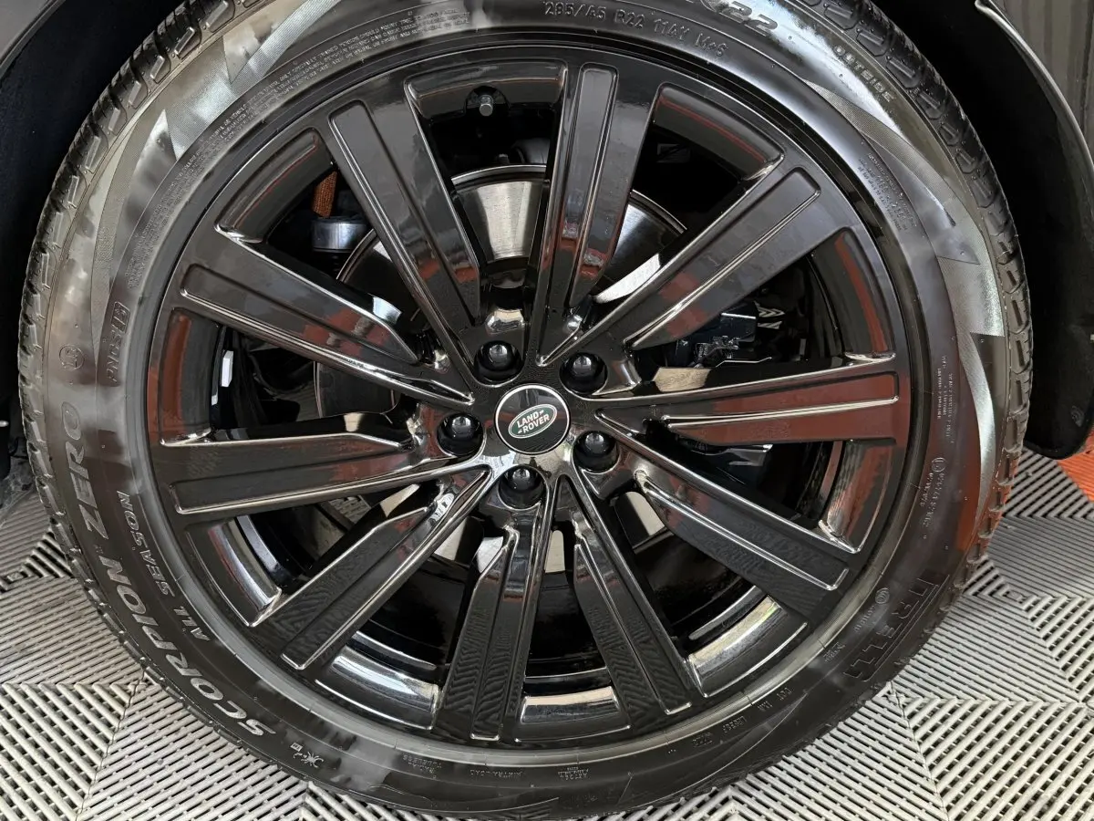 Gros plan sur la jante noire brillante du Range Rover PHEV P550e 2024 avec logo Land Rover au centre.