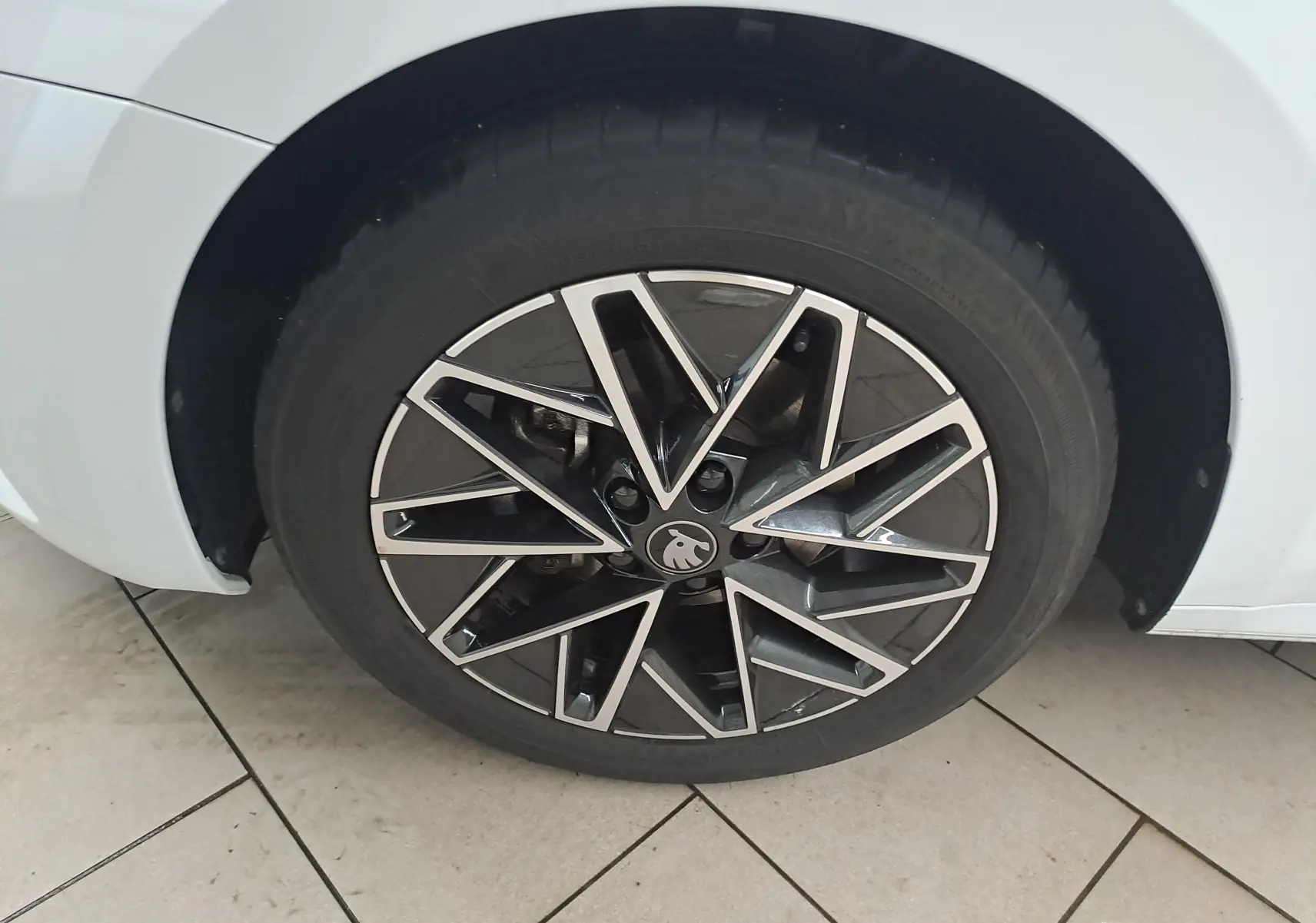 Gros plan sur la jante alliage 17'' Slagard Aero noir polie du côté avant droit d'une Skoda Octavia Combi blanc Moon.