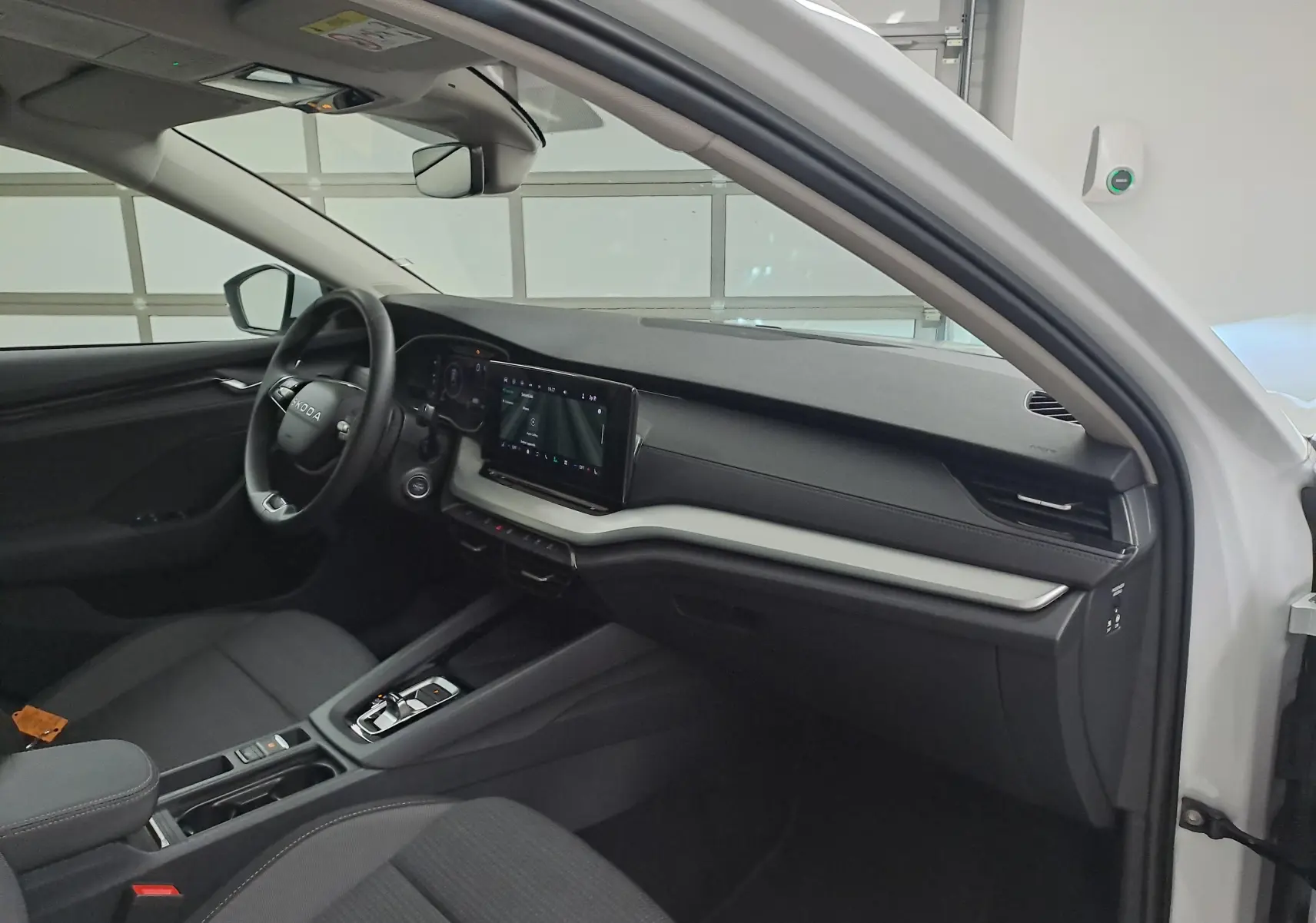 Vue intérieure côté conducteur de la Skoda Octavia Combi blanc Moon 2025, tableau de bord moderne avec écran tactile.