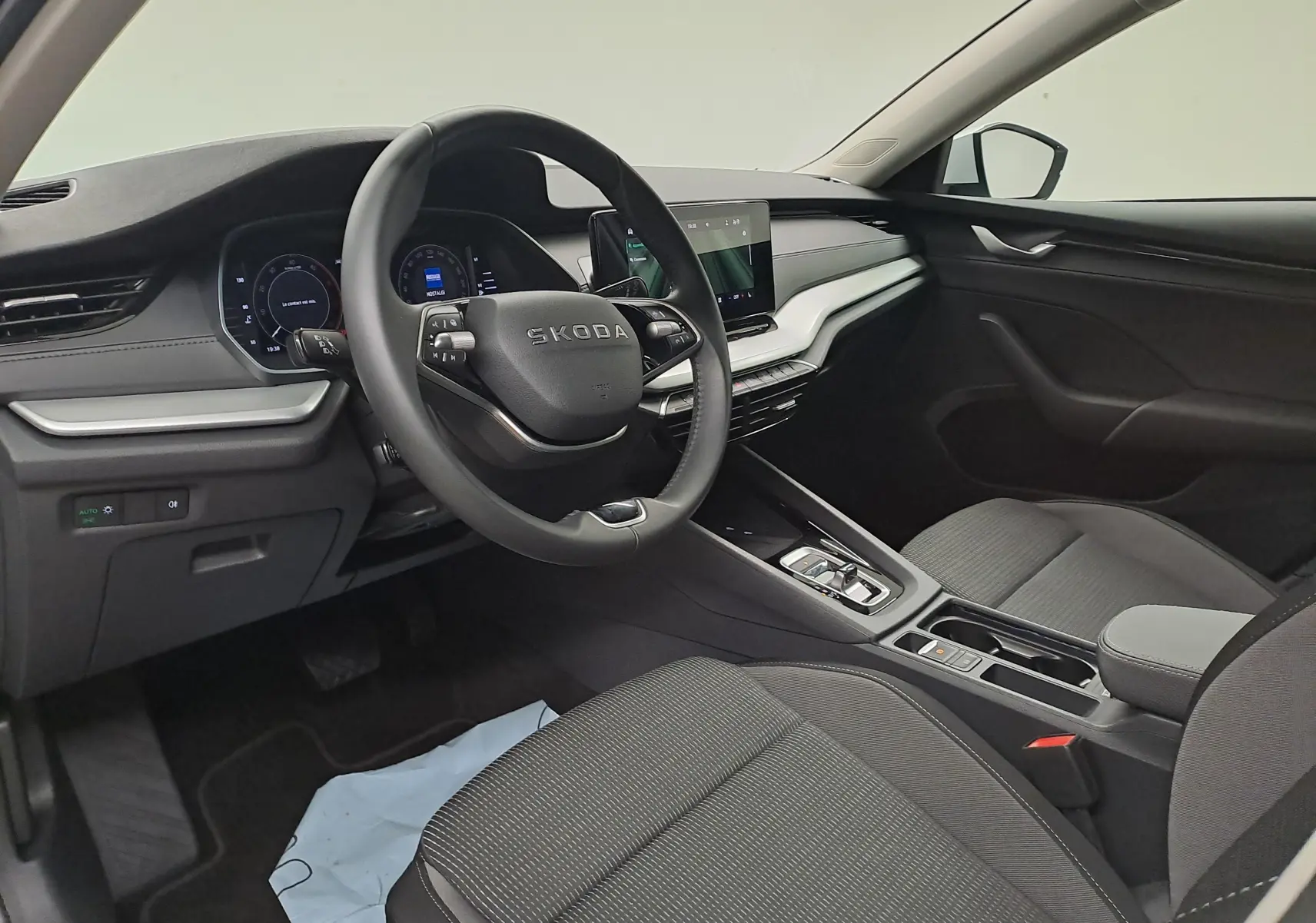 Vue intérieure côté conducteur de la Skoda Octavia Combi 2025 avec tableau de bord noir et volant multifonction.