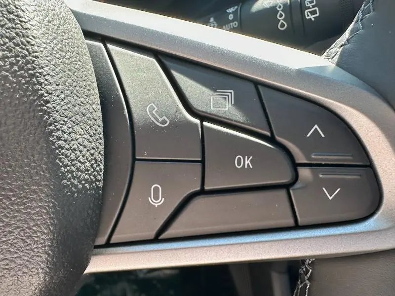Gros plan sur les commandes multifonctions noires du volant du Dacia Bigster 2025, avec touches appel et navigation.