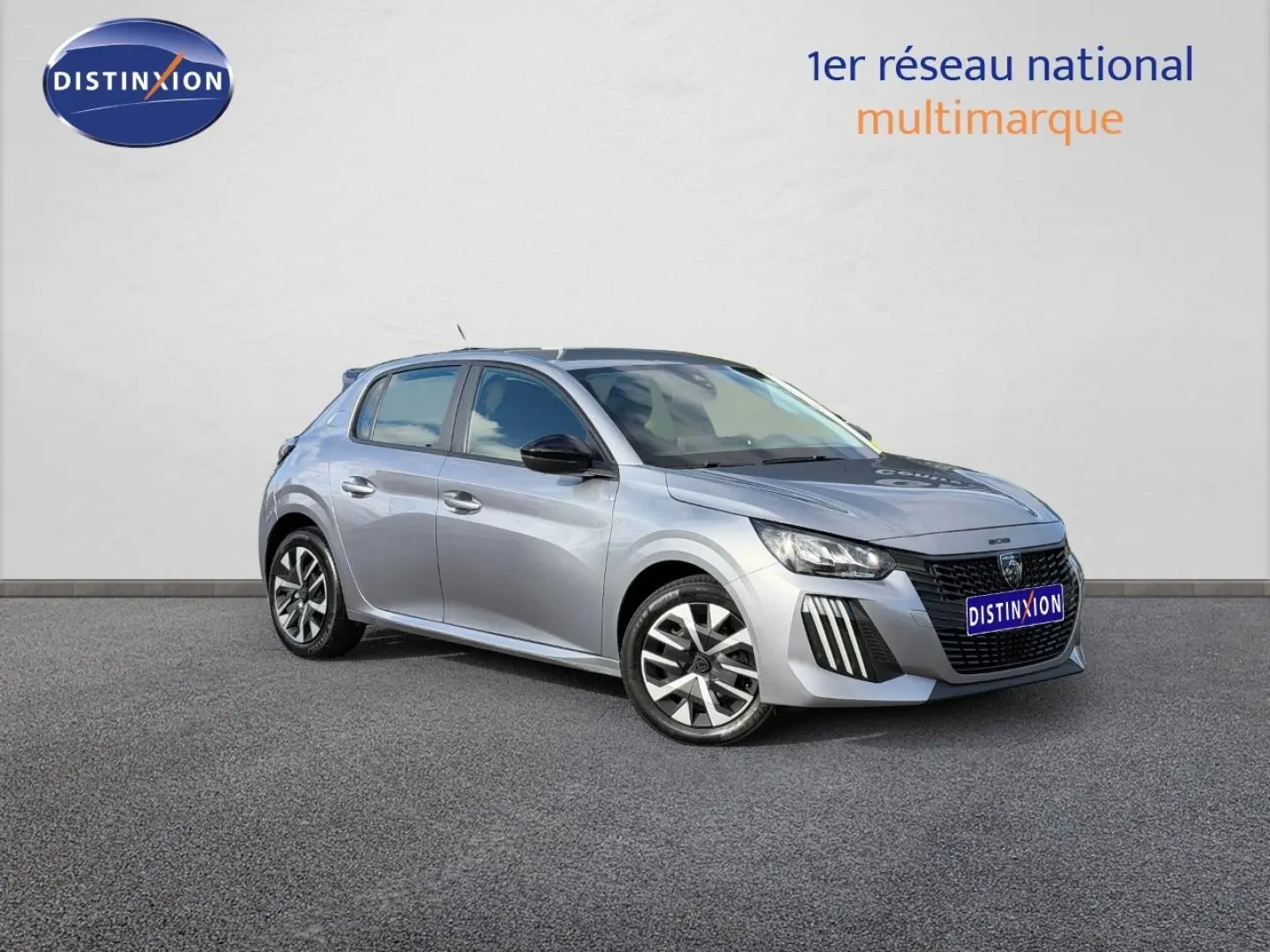 Peugeot 208 gris Artense vue 3/4 avant droit, avec jantes alliage et calandre noire distinctive.