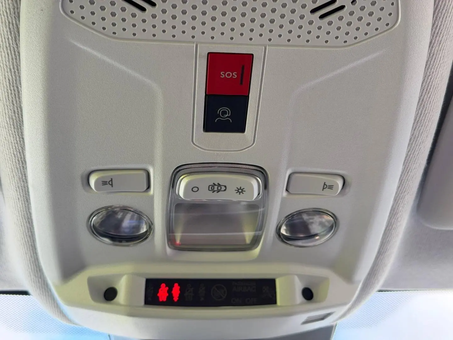 Vue en gros plan du plafonnier intérieur gris clair avec boutons SOS et éclairage de la Peugeot 208 2025.