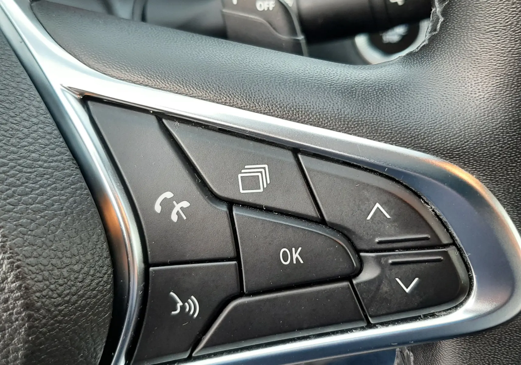 Gros plan sur les commandes multifonctions du volant à droite du Renault Captur bleu iron 2020 avec finition noire.