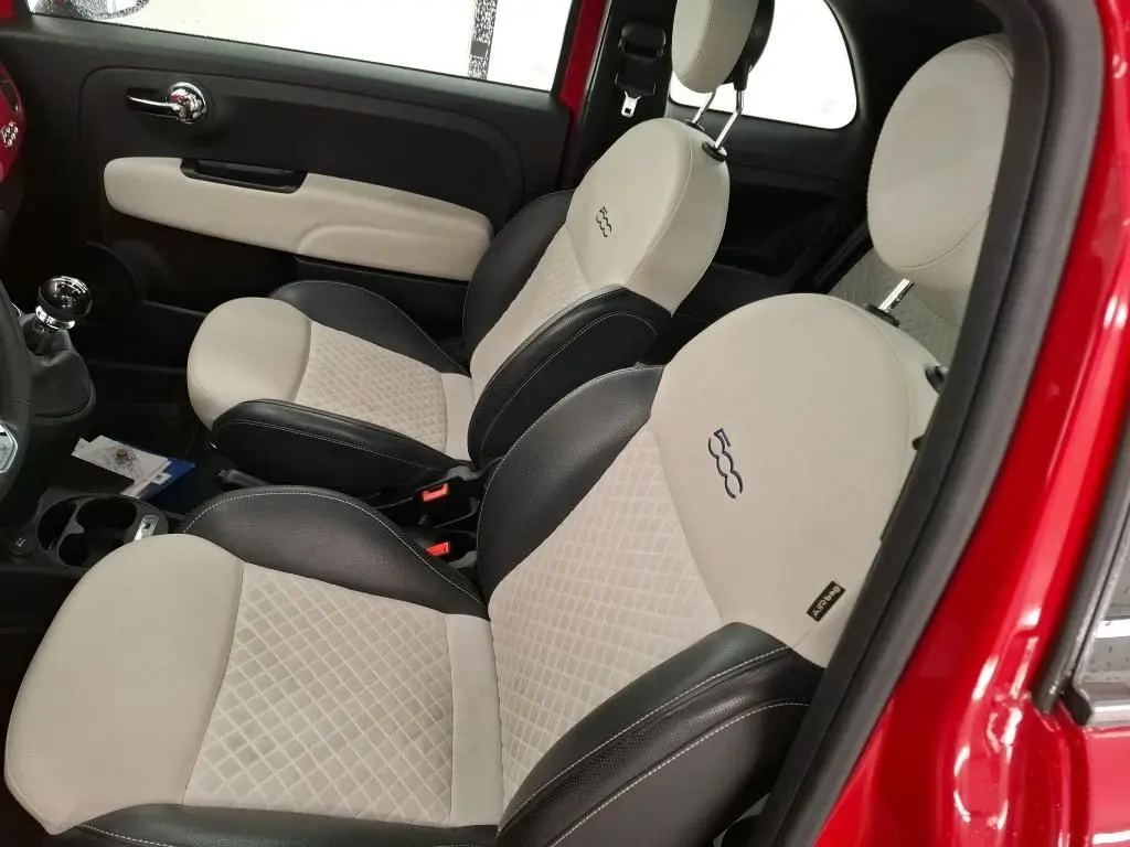 Vue intérieure côté droit montrant les sièges bi-ton beige et noir avec logo 500 sur une FIAT 500 rouge Dolcevita 2021.