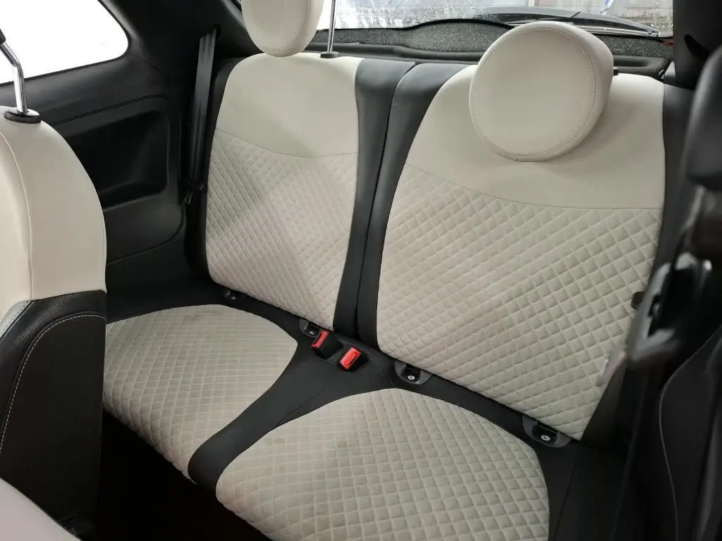Vue intérieure sur les sièges arrière beige matelassés avec appuie-têtes ronds de la Fiat 500 Dolcevita rouge de 2021.