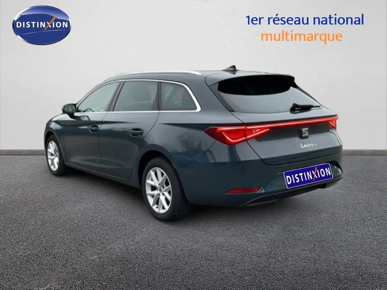 SEAT Leon IV gris Fiord vue 3/4 arrière côté gauche, break 5 portes avec feux arrière LED allumés.