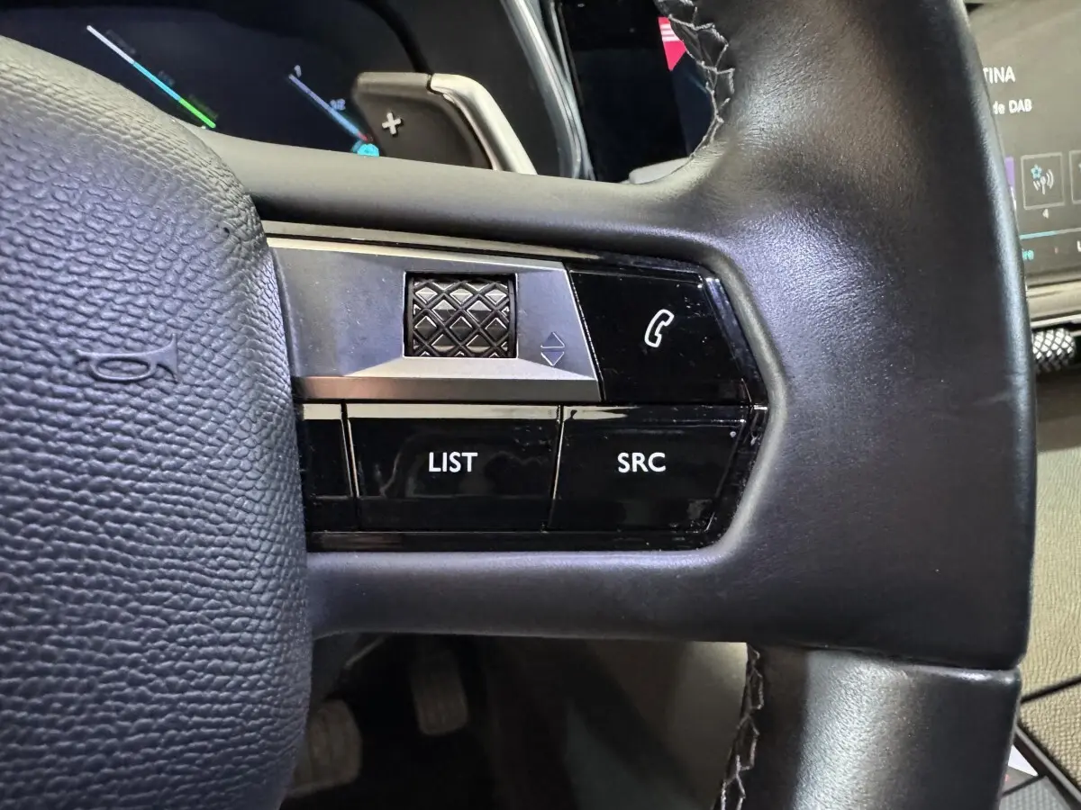 Gros plan sur le volant cuir noir du DS7 Crossback E-TENSE 225, avec commandes multifonctions et molette tactile.