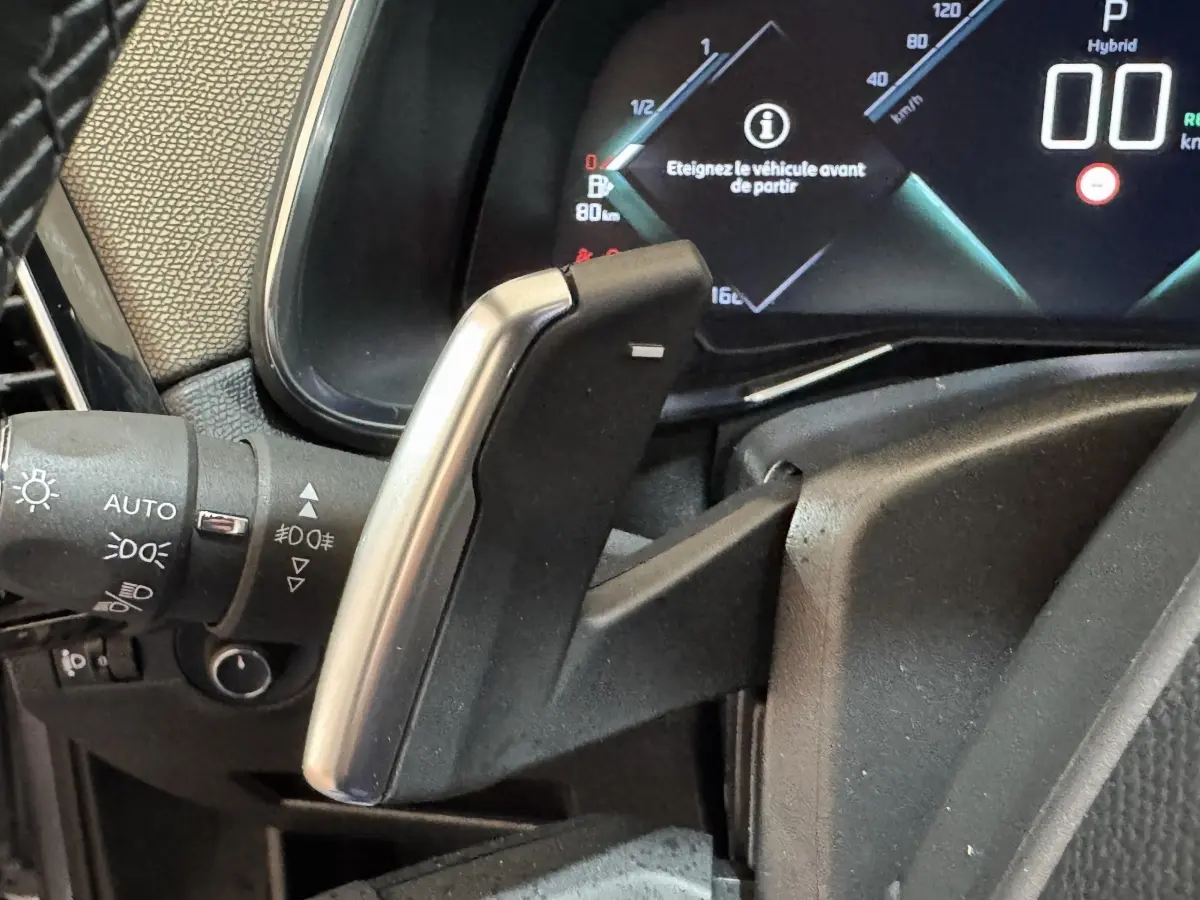 Gros plan sur la palette de changement de vitesse en aluminium du DS7 Crossback E-TENSE 225, tableau de bord numérique visible.