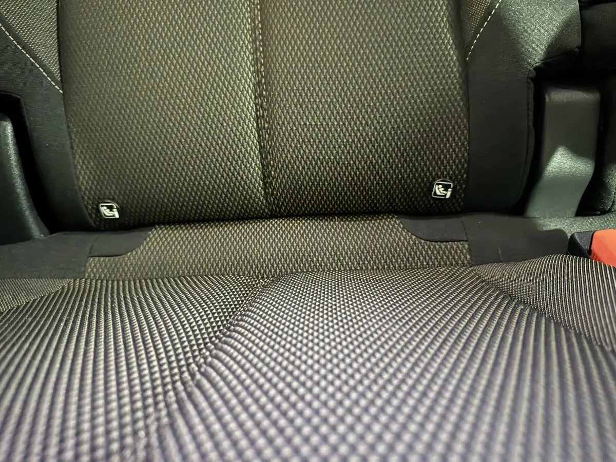 Gros plan sur la banquette arrière en tissu gris foncé du DS7 Crossback E-TENSE 225 BASTILLE + avec fixation Isofix visible.