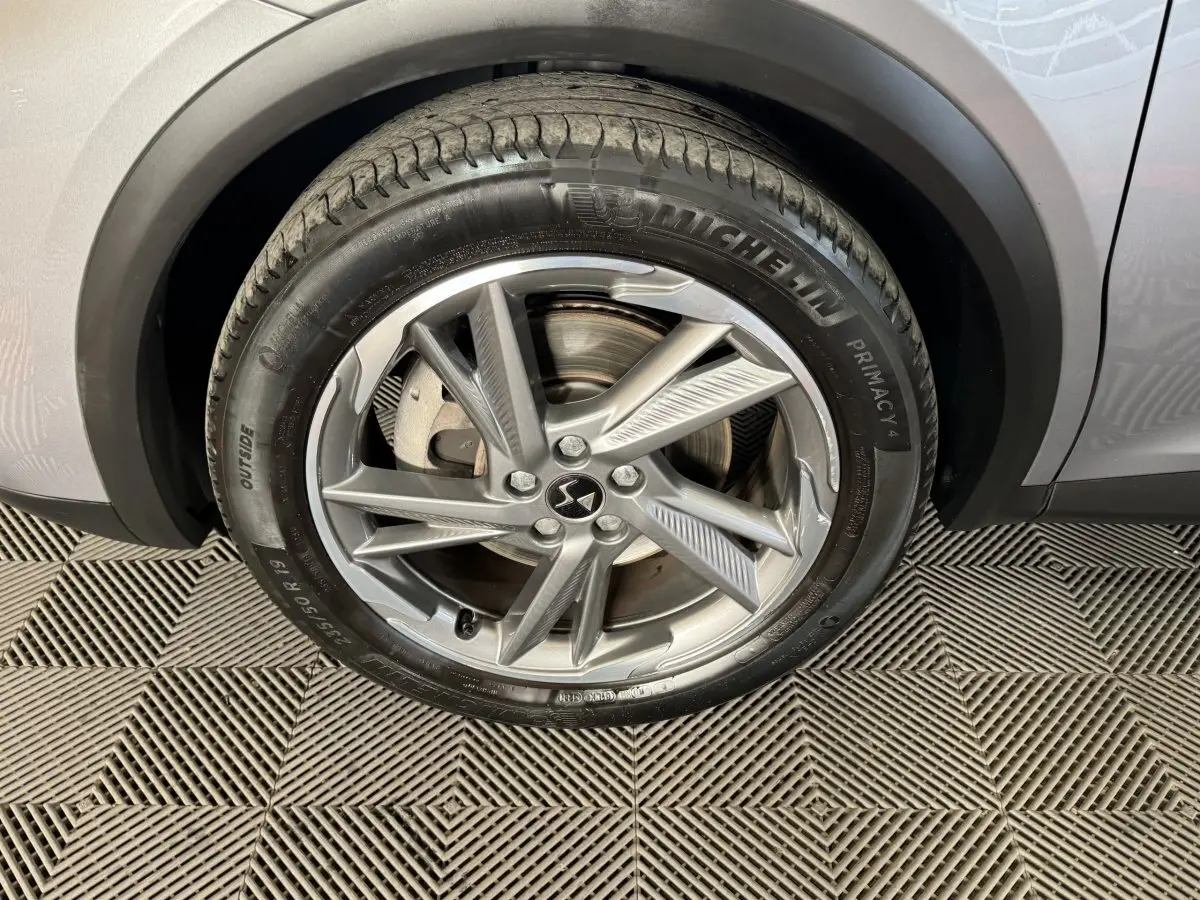 Gros plan sur la roue avant droite gris foncé du DS7 Crossback E-TENSE 225 Bastille+ avec jante alliage et pneu Michelin.