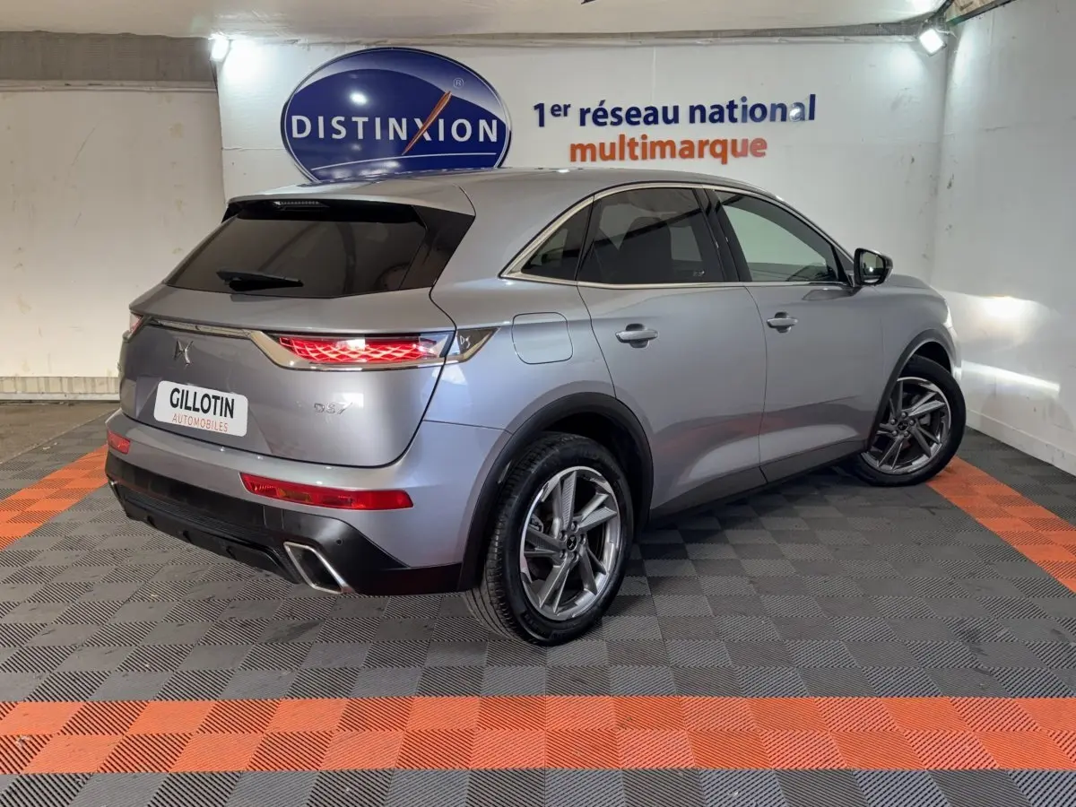 DS7 Crossback E-TENSE gris foncé vu en 3/4 arrière droit, avec feux arrière allumés et jantes alliage.