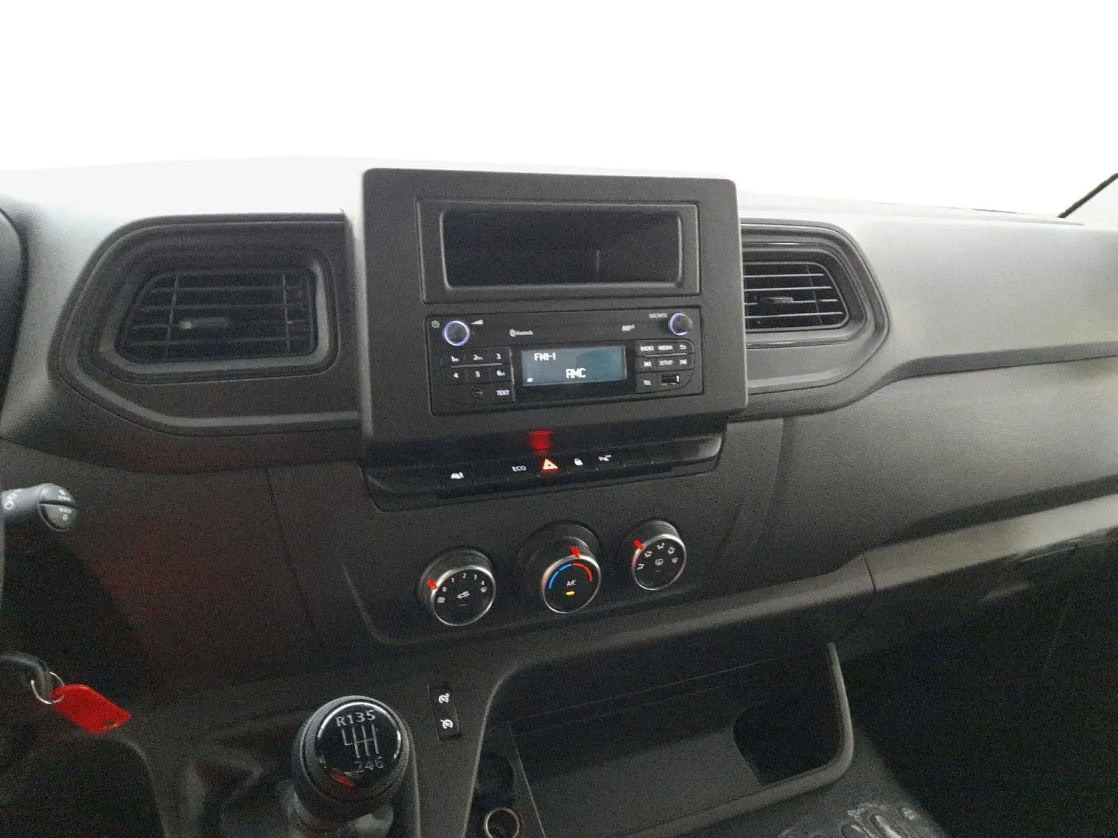 Vue rapprochée du tableau de bord noir du Renault Master 2023 avec commandes de climatisation et radio intégrée.