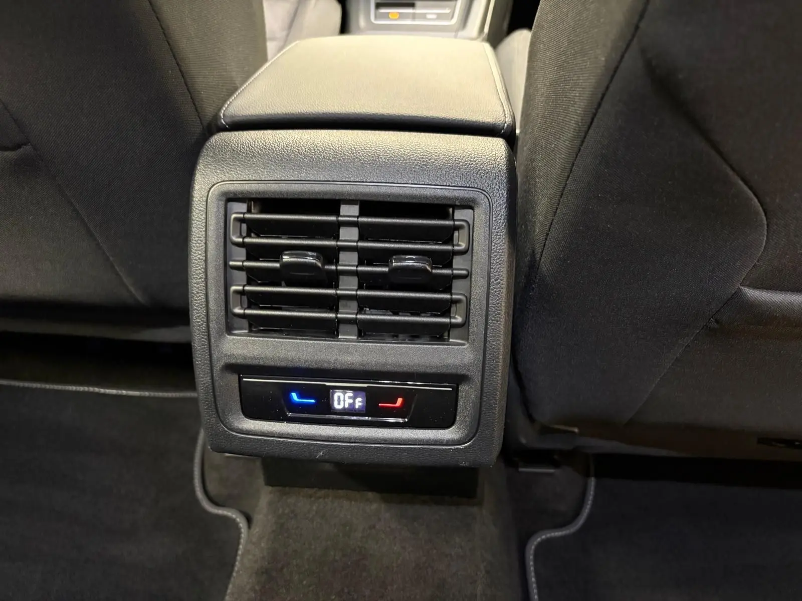 Vue rapprochée de la ventilation arrière et commandes de climatisation sur la console centrale d'une Volkswagen Golf 2025 reflet d'argent.
