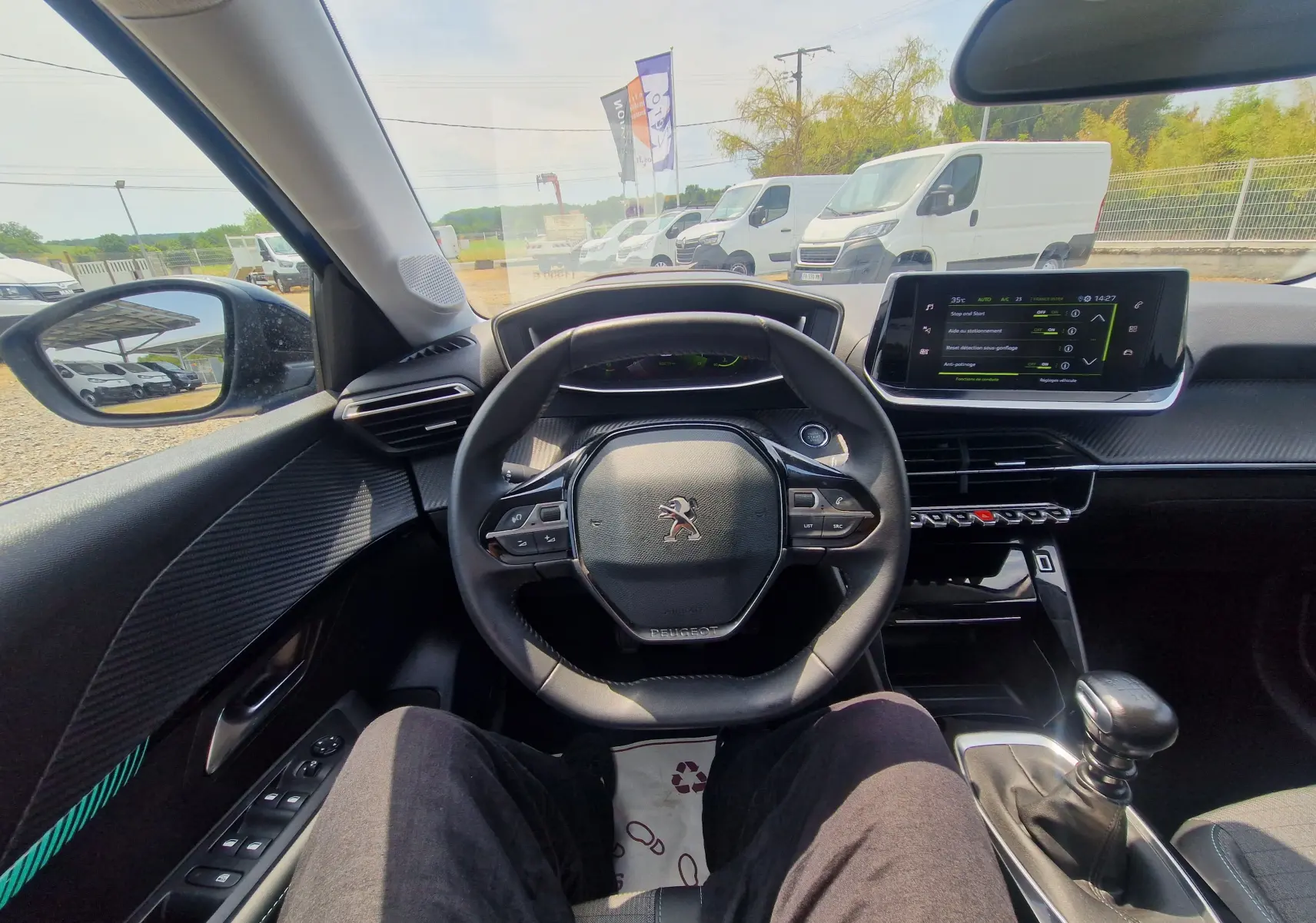 Vue intérieure centrée sur le volant Peugeot 208 1.2 PureTech 110 avec tableau de bord numérique et écran tactile.
