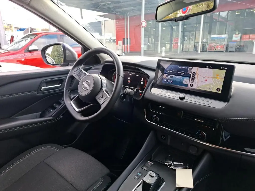 Vue intérieure côté conducteur du Nissan Qashqai e-POWER 2023 avec tableau de bord numérique et écran tactile central.