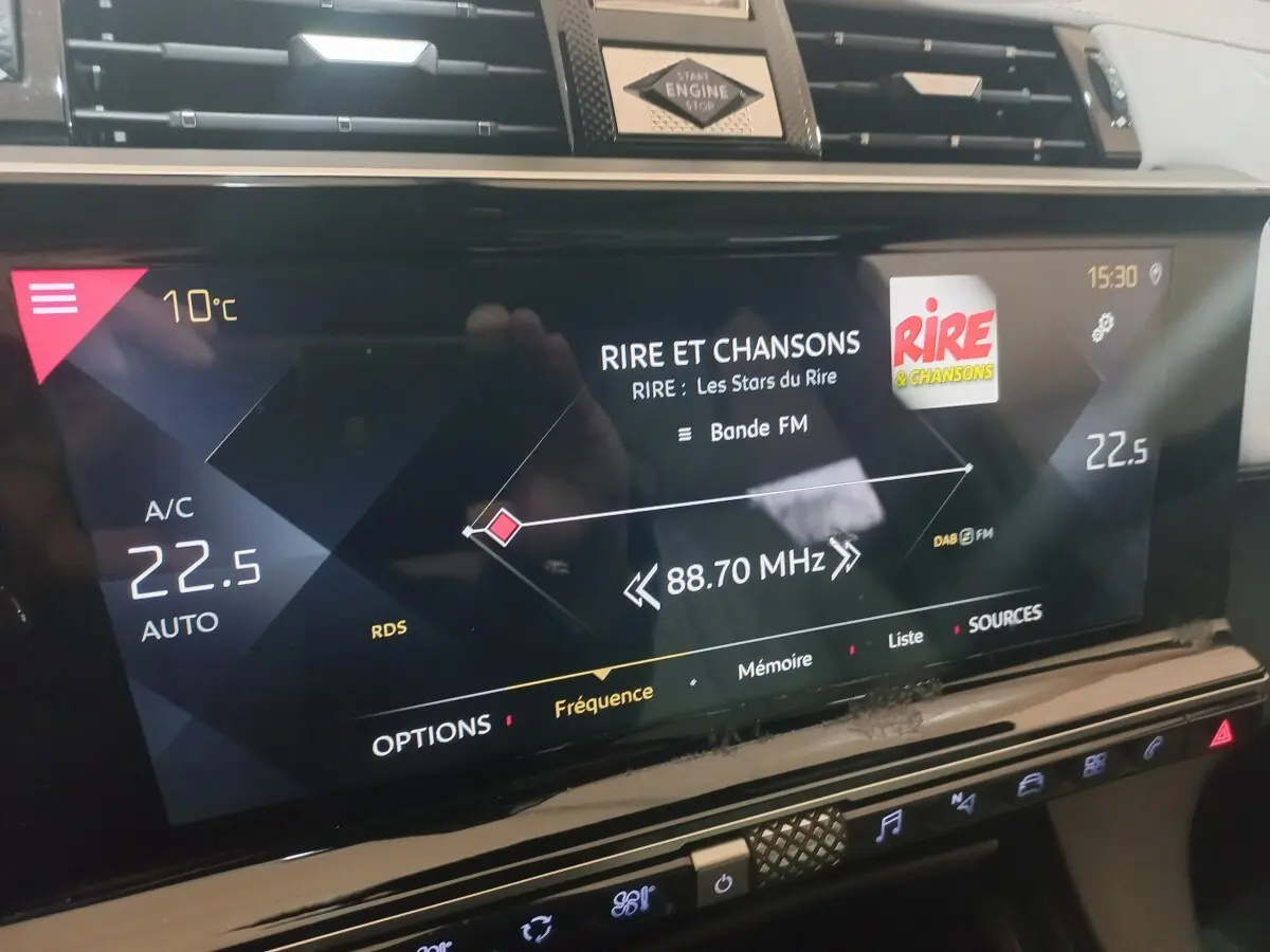 Gros plan sur l’écran tactile central du DS7 Crossback gris foncé, affichant la radio FM et la température intérieure.
