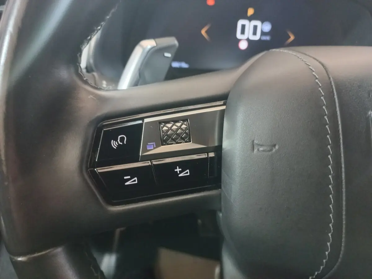 Gros plan sur les commandes gauche du volant cuir noir du DS7 Crossback 2021, avec touches de volume et reconnaissance vocale.