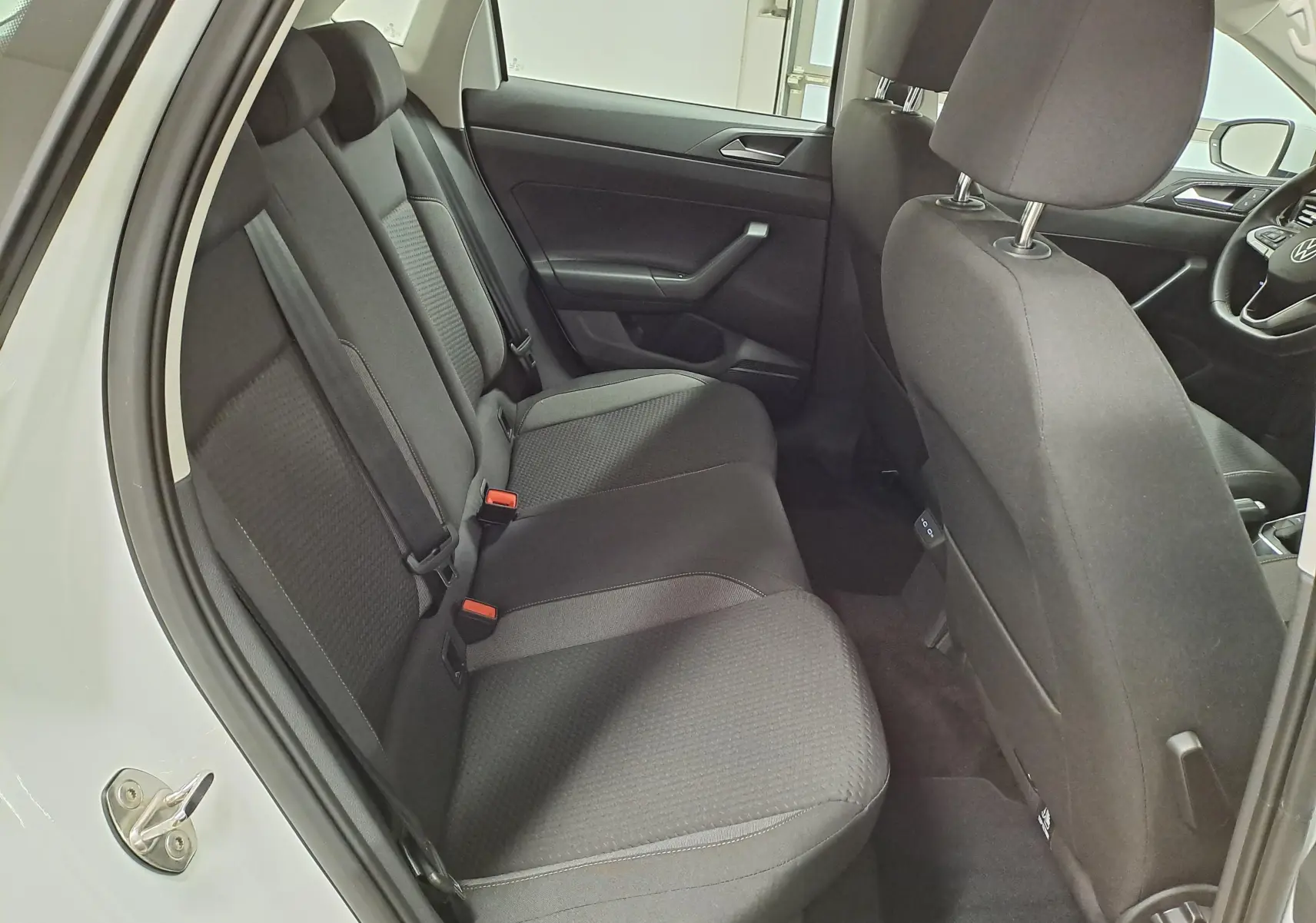 Vue intérieure côté gauche sur les sièges arrière noirs d'une Volkswagen Polo blanc pur 2024, version Life Plus.