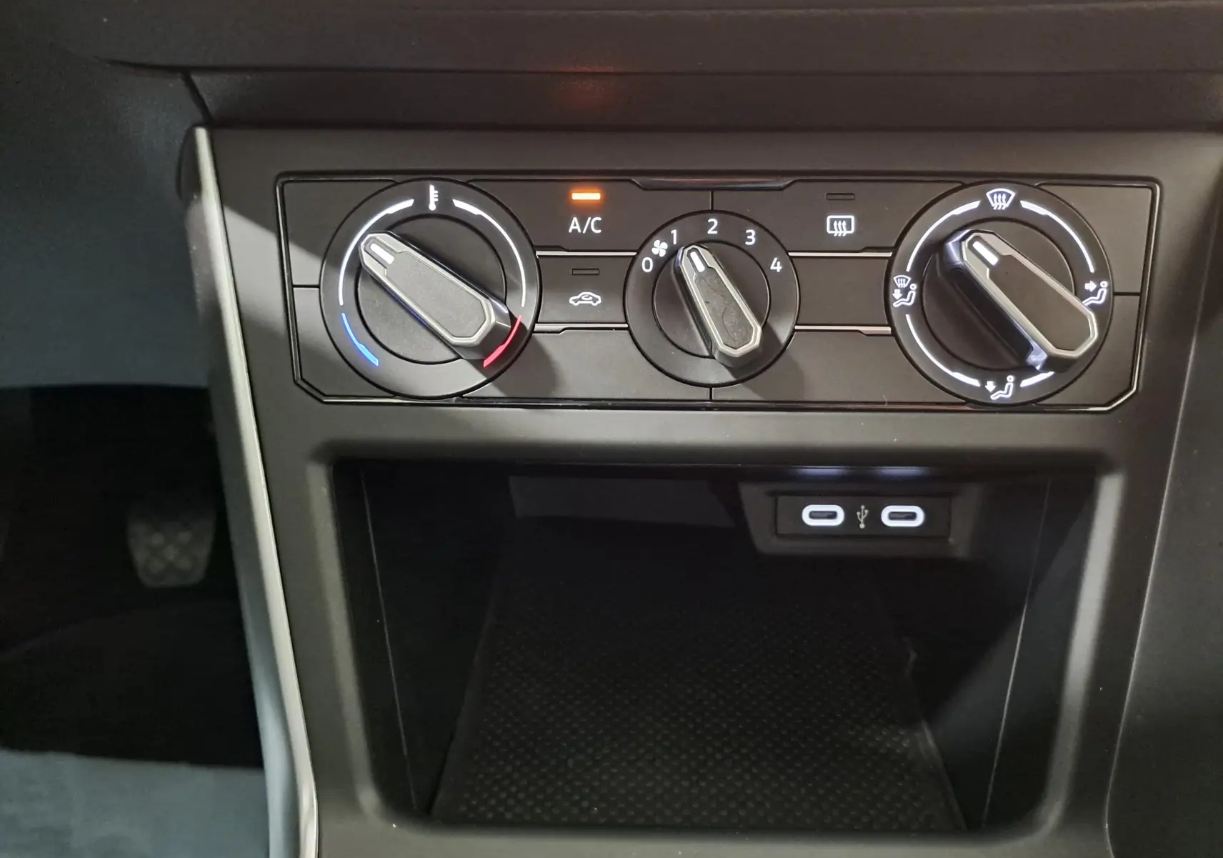 Gros plan sur les commandes de climatisation manuelle et les ports USB de la Volkswagen Polo blanc pur 2024.