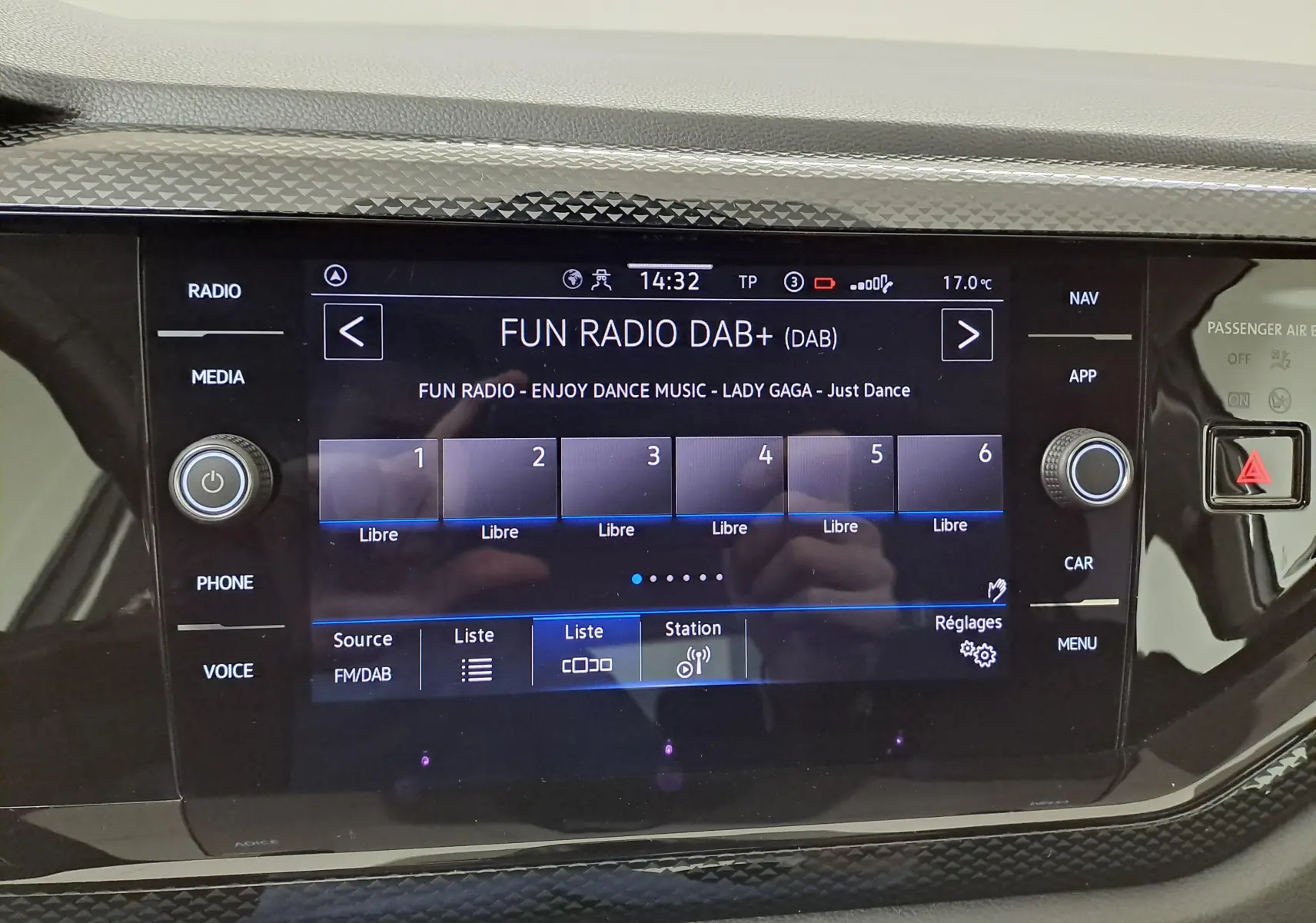 Écran tactile central de la Volkswagen Polo 2024 affichant la radio DAB+ avec commandes autour et finition noire brillante.
