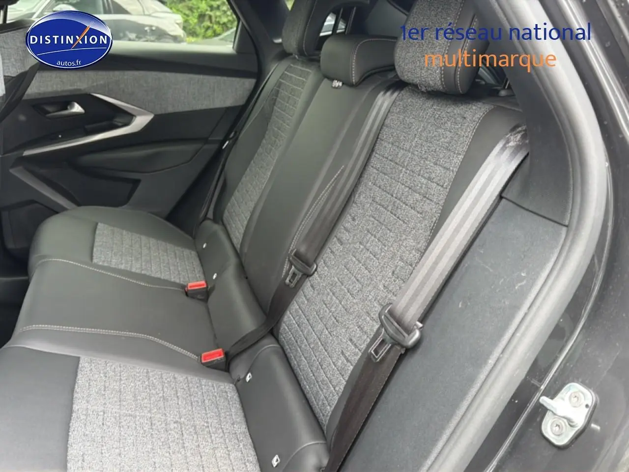 Vue intérieure côté droit montrant la banquette arrière bi-matière grise et noire du Peugeot 3008 gris titane 2025.