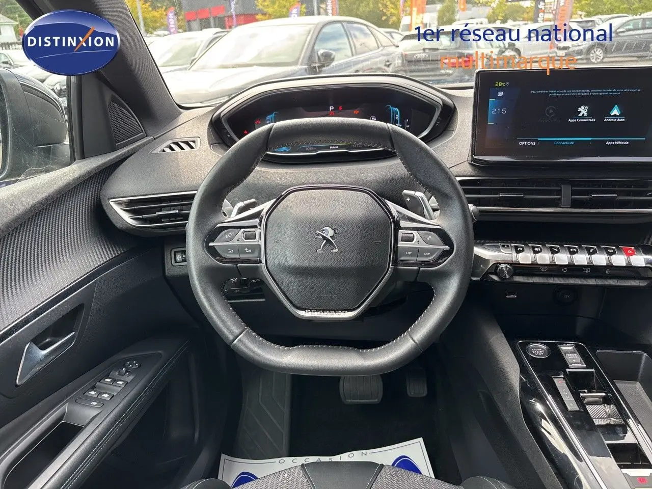 Vue intérieure centrée sur le volant cuir noir du Peugeot 3008 Hybrid 2024 avec tableau de bord digital et écran tactile.