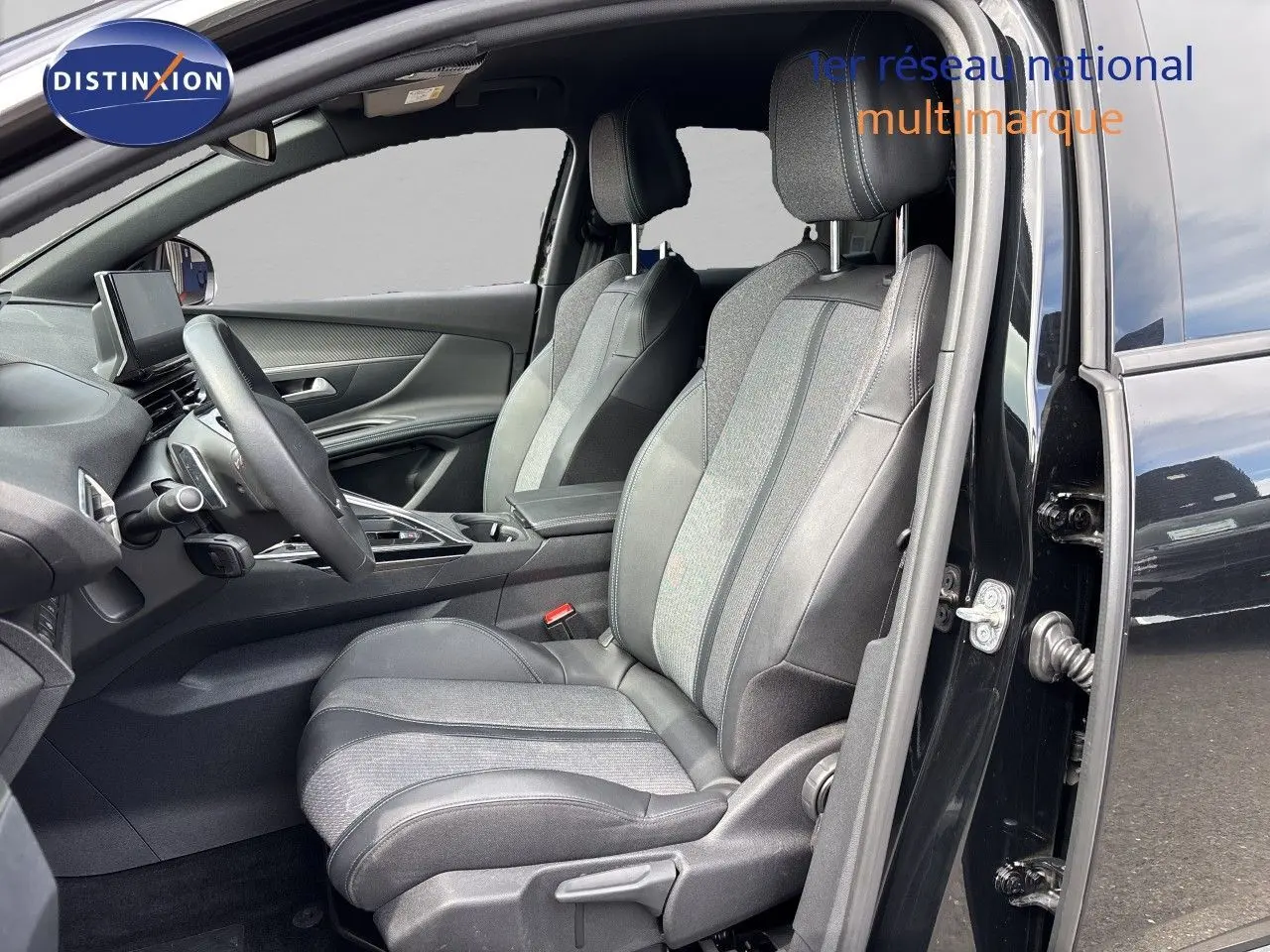 Vue intérieure côté conducteur du Peugeot 3008 Hybrid 180ch noir métal, sièges tissu et cuir avec surpiqûres contrastées.