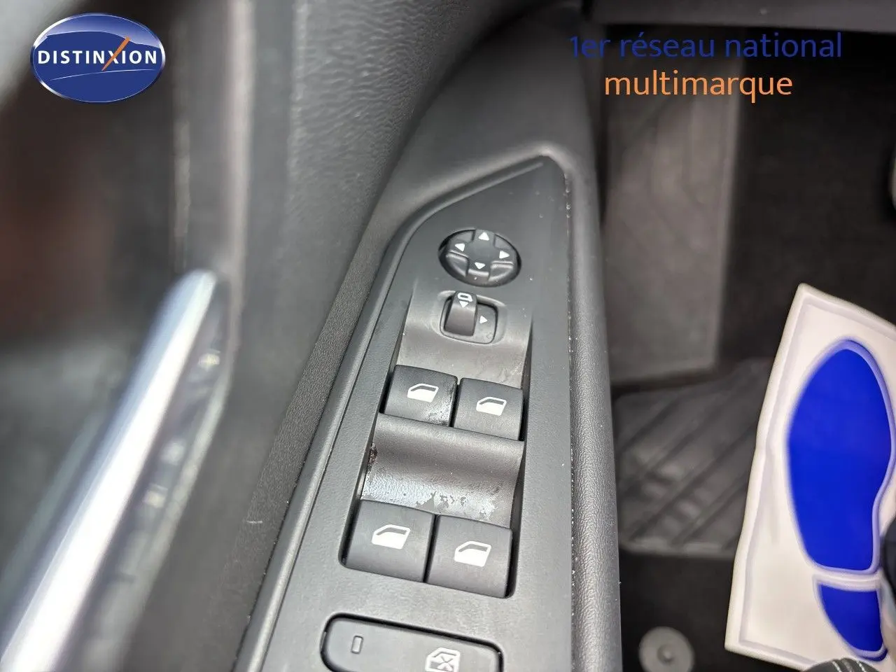 Gros plan sur les commandes des vitres électriques côté conducteur du Peugeot 3008 noir métal hybride 2024.