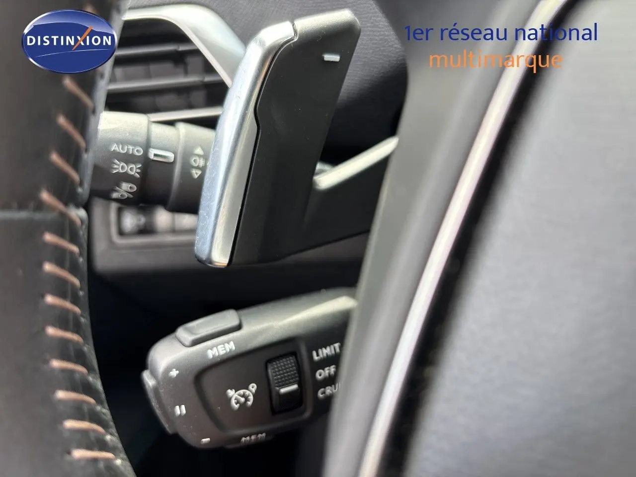 Détail du levier de commande du régulateur de vitesse sur le volant d’un Peugeot 3008 Hybrid 180ch noir métal.