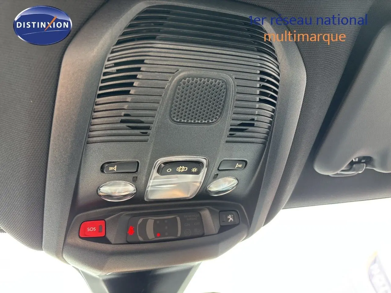 Vue en contre-plongée du plafonnier noir avec commandes d’éclairage et bouton SOS du Peugeot 3008 Hybrid 2024.