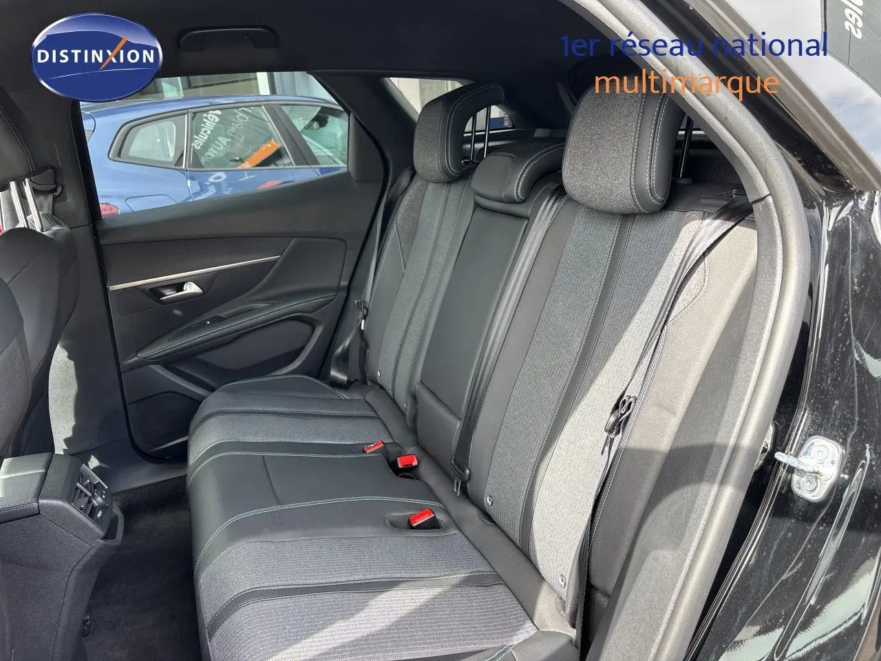 Vue intérieure côté droit montrant la banquette arrière en tissu et cuir gris du Peugeot 3008 Hybrid 2024 noir métal.